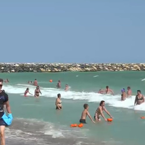 Turist scos cu forța din apă și încătușat de jandarmi, în stațiunea Venus. Pe litoral sunt valuri mari și e arborat steagul roșu